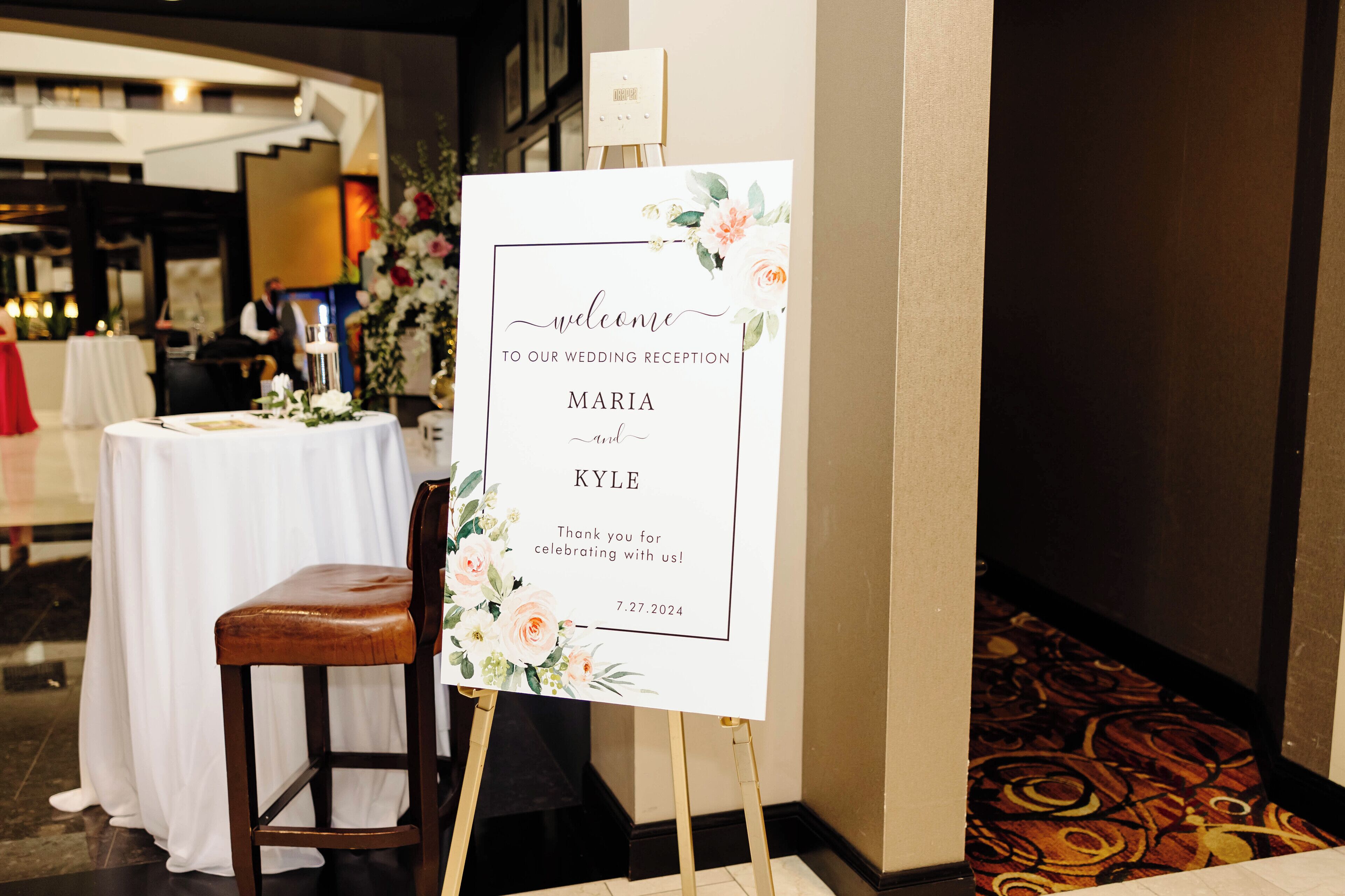 A wedding reception sign with floral decorations.