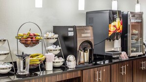 A coffee station with a coffee machine, fruit bowls, and a beverage dispenser. - Sleep Inn & Suites Spring Lake - Fayetteville near Fort Bragg (Spring Lake)