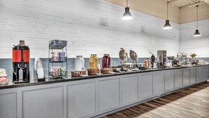 A long counter with various food and drink items, including coffee machines and condiments.