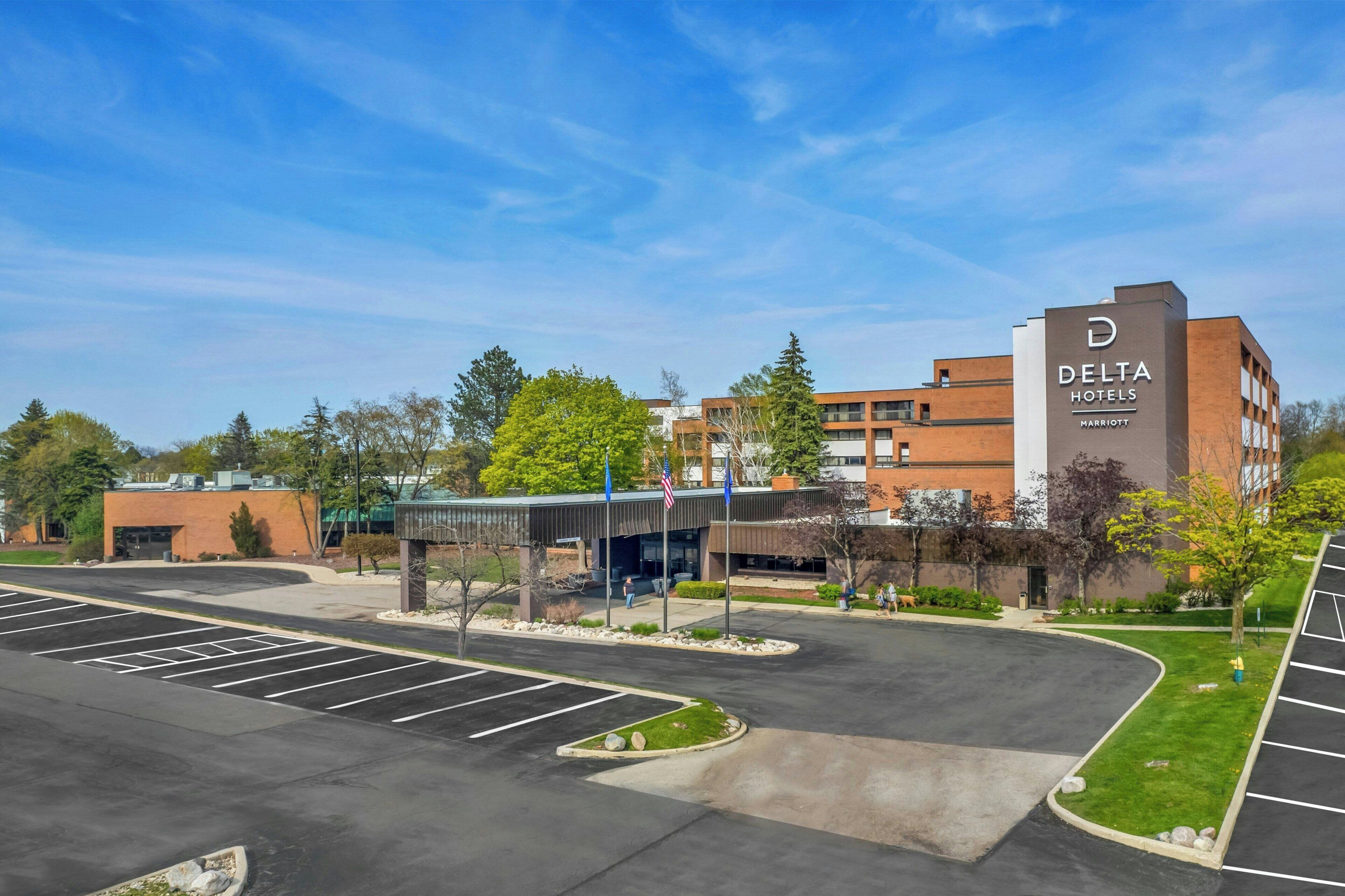 A Delta Hotels Marriott building with a parking lot and surrounding greenery.