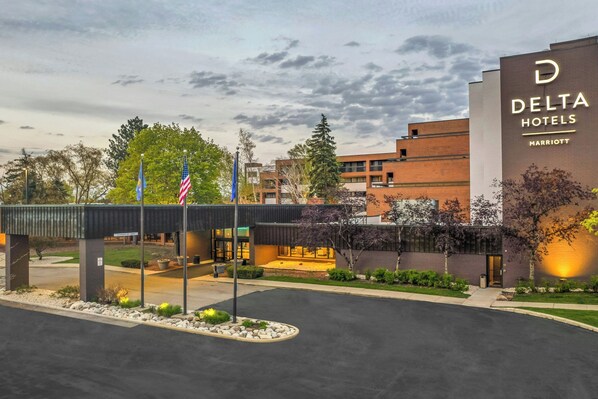 A Delta Hotels Marriott building with a modern design, featuring a prominent entrance and a landscaped area in front.