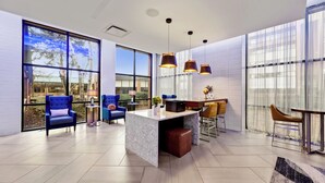 Un'ampia hall con ampie finestre, una reception in marmo e confortevoli zone salotto.