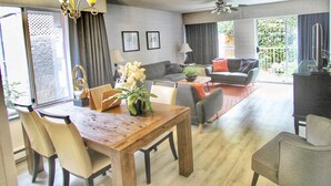 A modern living room with a sofa, coffee table, and dining area with chairs and a wooden table. - Best Western Plus Regency Inn & Conference Centre (Abbotsford)