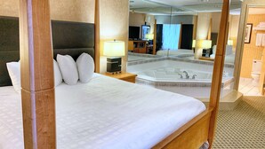 A four-poster bed with a large mirror, a bathtub, and a television in the background. - Best Western Plus Regency Inn & Conference Centre (Abbotsford)