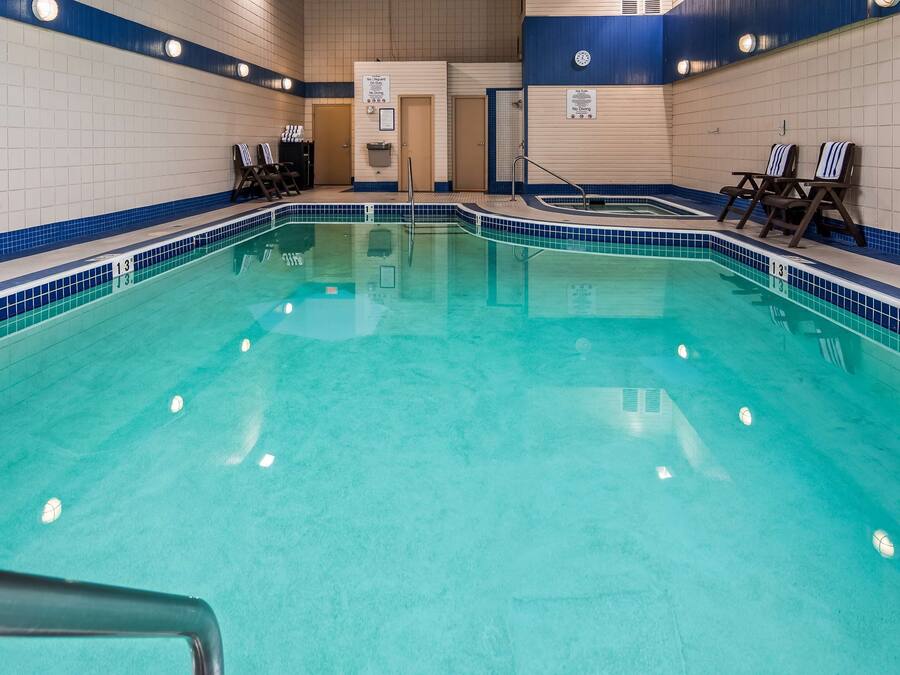 Una piscina interior amb aigua cristal·lina blava, línies de separació i gandules.