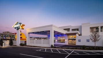 A hotel with a modern design, featuring a covered outdoor area and a prominent sign.
