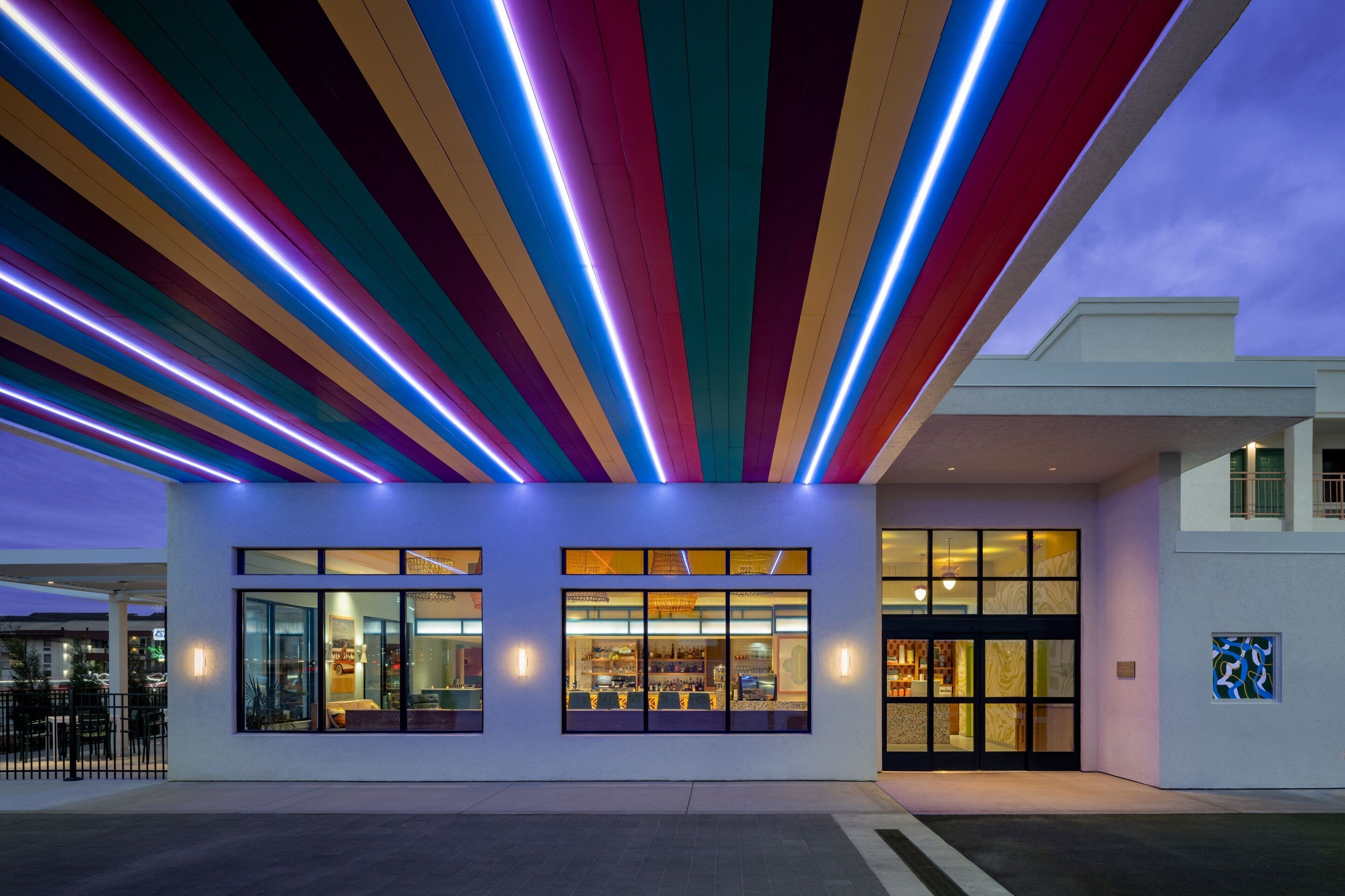 A modern building with large windows and a colorful ceiling design.
