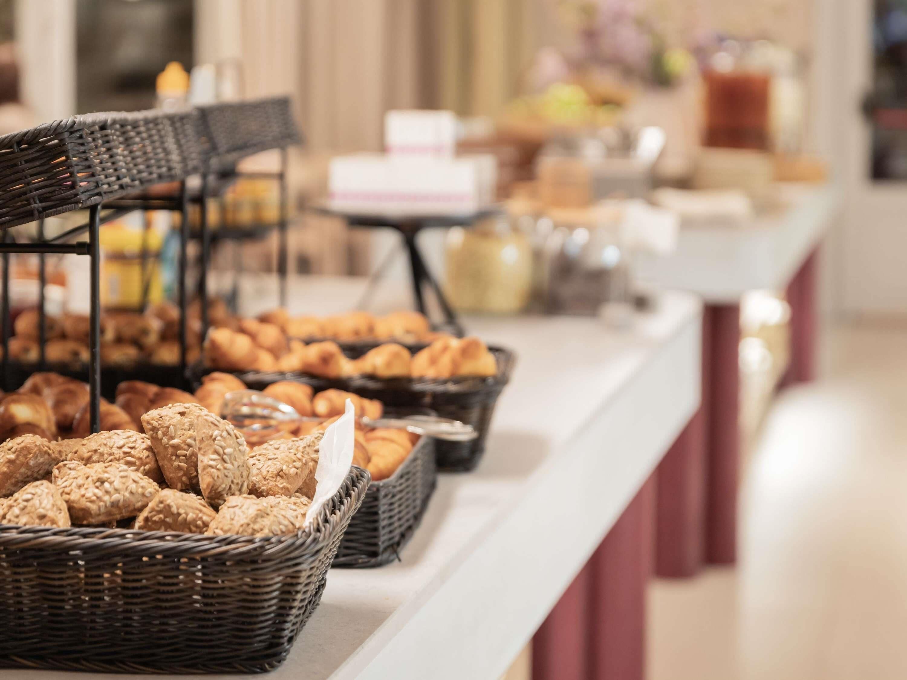 A buffet with various food items including bread and pastries.