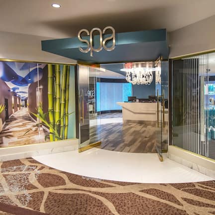 A spa area with a reception desk, bamboo decor, and a chandelier.