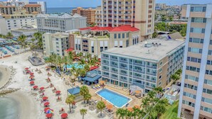 Un hôtel doté d’une piscine, d’un espace de plage et de plusieurs bâtiments.