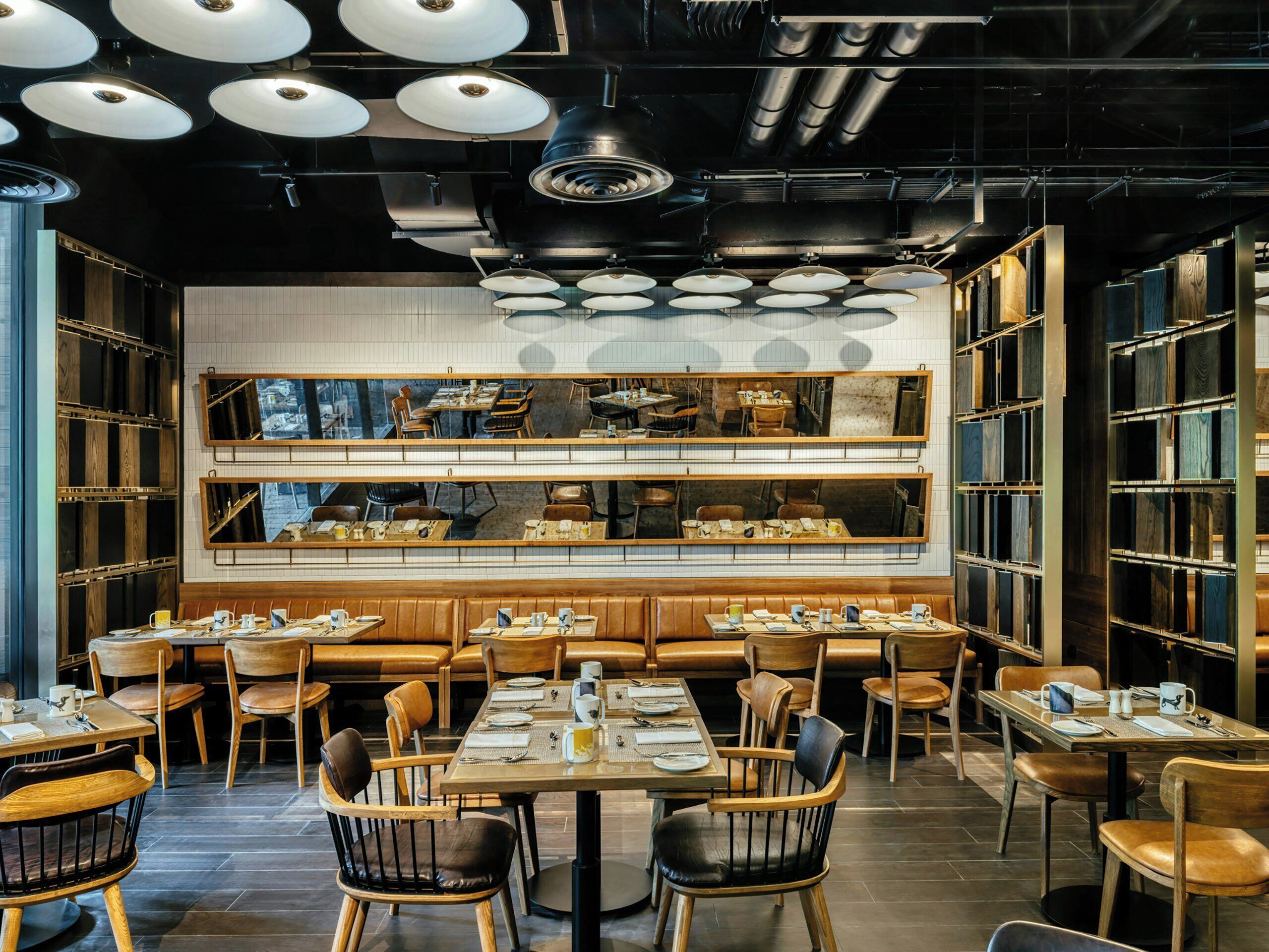 L’intérieur d’un restaurant, avec plusieurs tables, des chaises et un bar central.