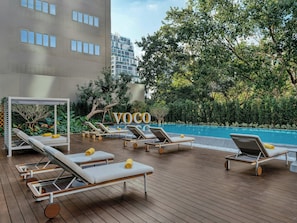 A rooftop pool area with lounge chairs and a canopy structure. - voco Bangkok Surawong by IHG (Bangkok)