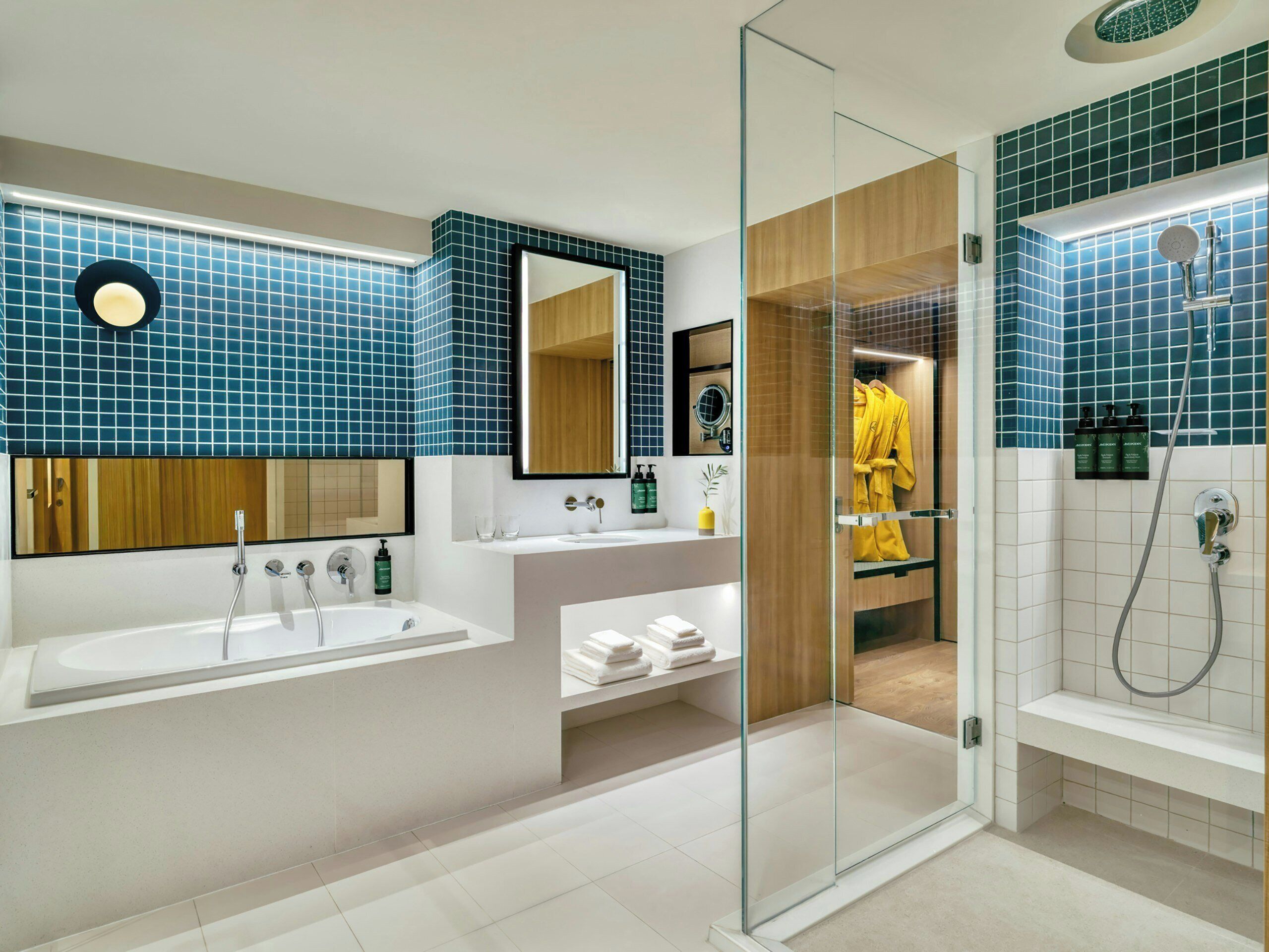 Een moderne badkamer met een douchecabine van glas, een wastafel met spiegel en een bad.