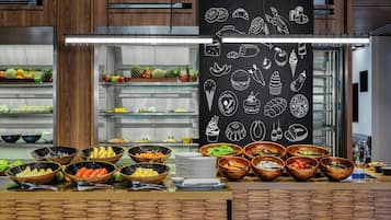 A buffet setup with various food items and a chalkboard menu.