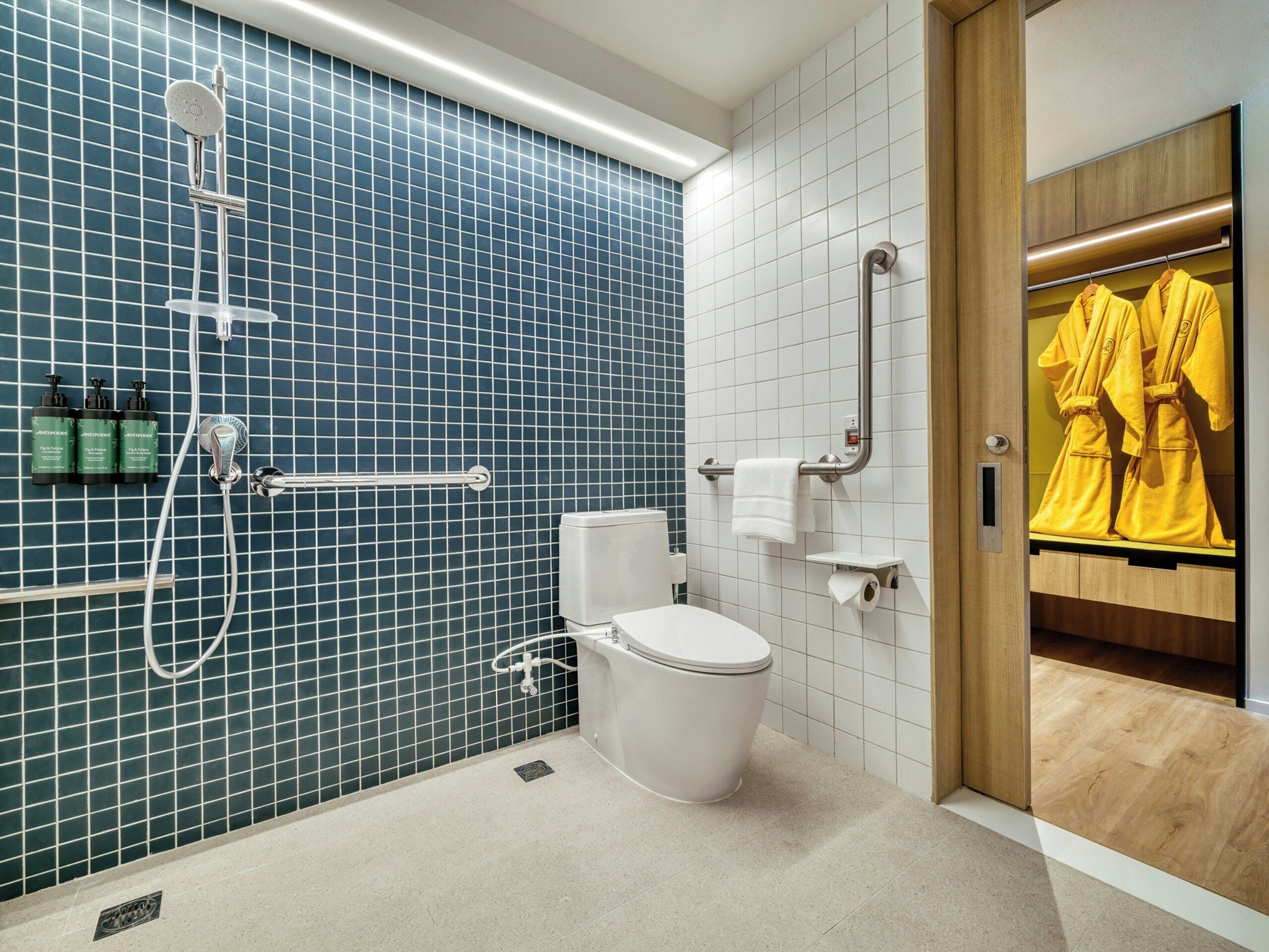 Ein modernes Badezimmer mit Dusche, Toilette und Handtuchhalter.