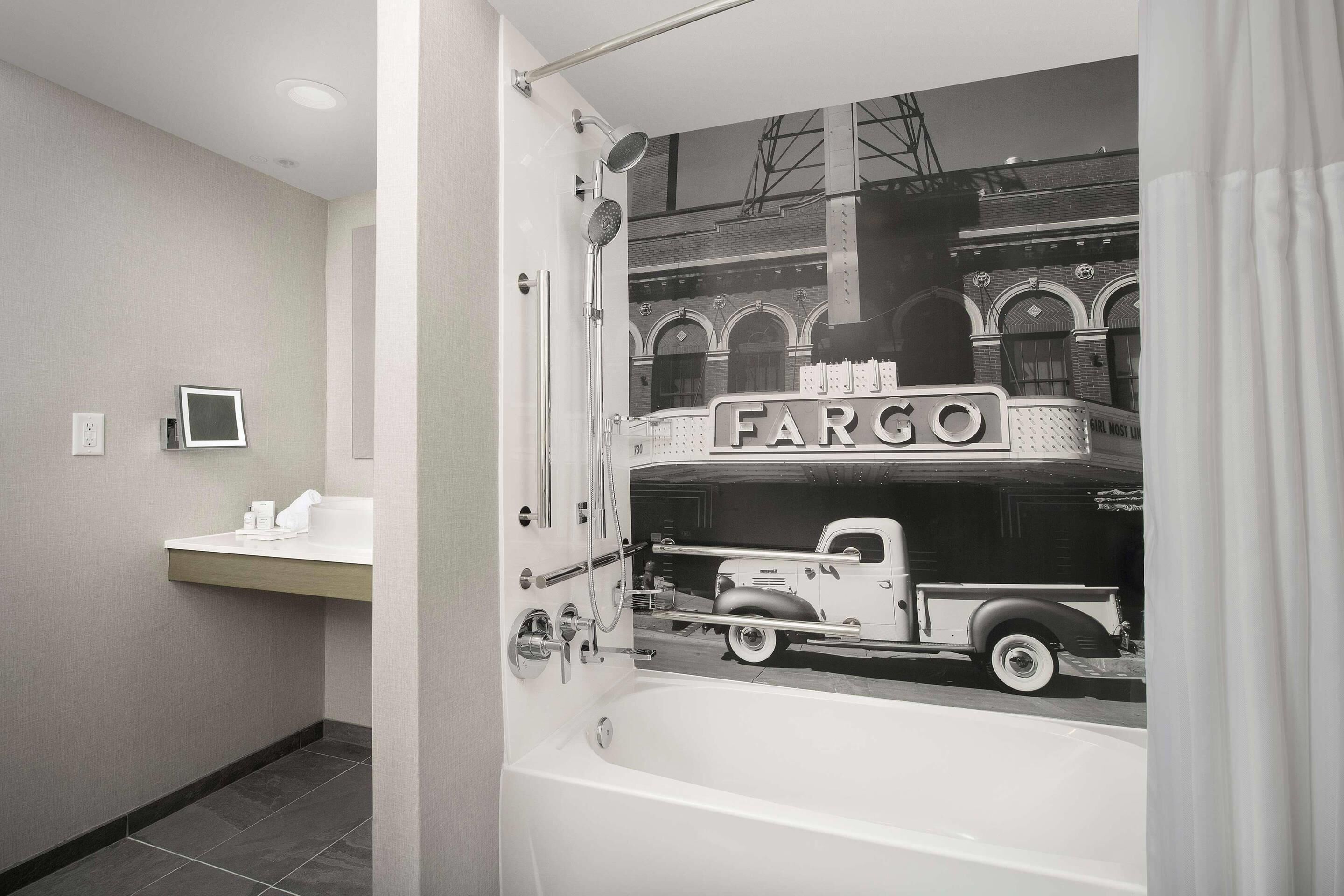 Un baño con bañera, lavamanos y una ventana que muestra un coche antiguo.