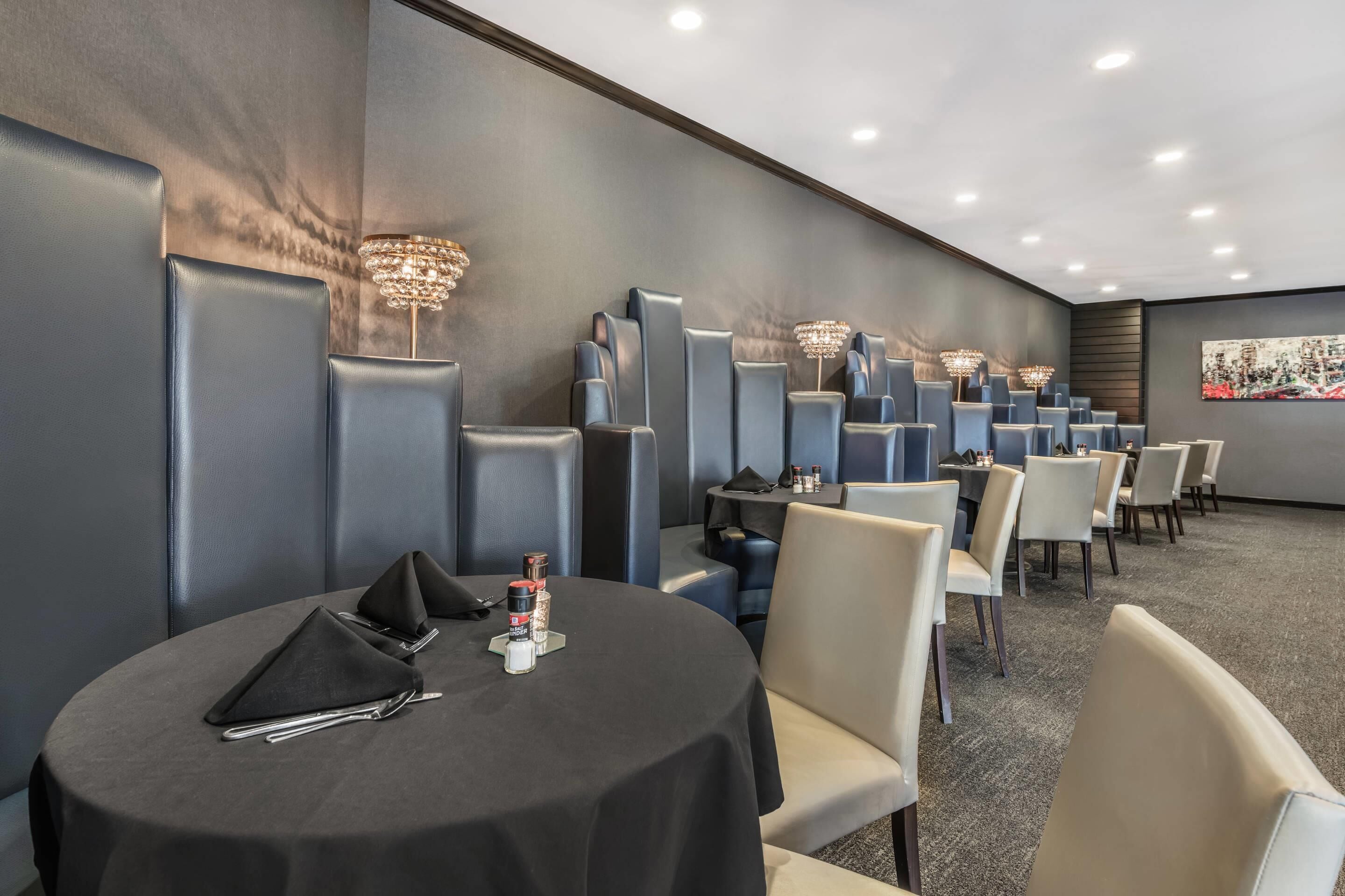 A conference room with round tables, chairs, and wall-mounted chandeliers.