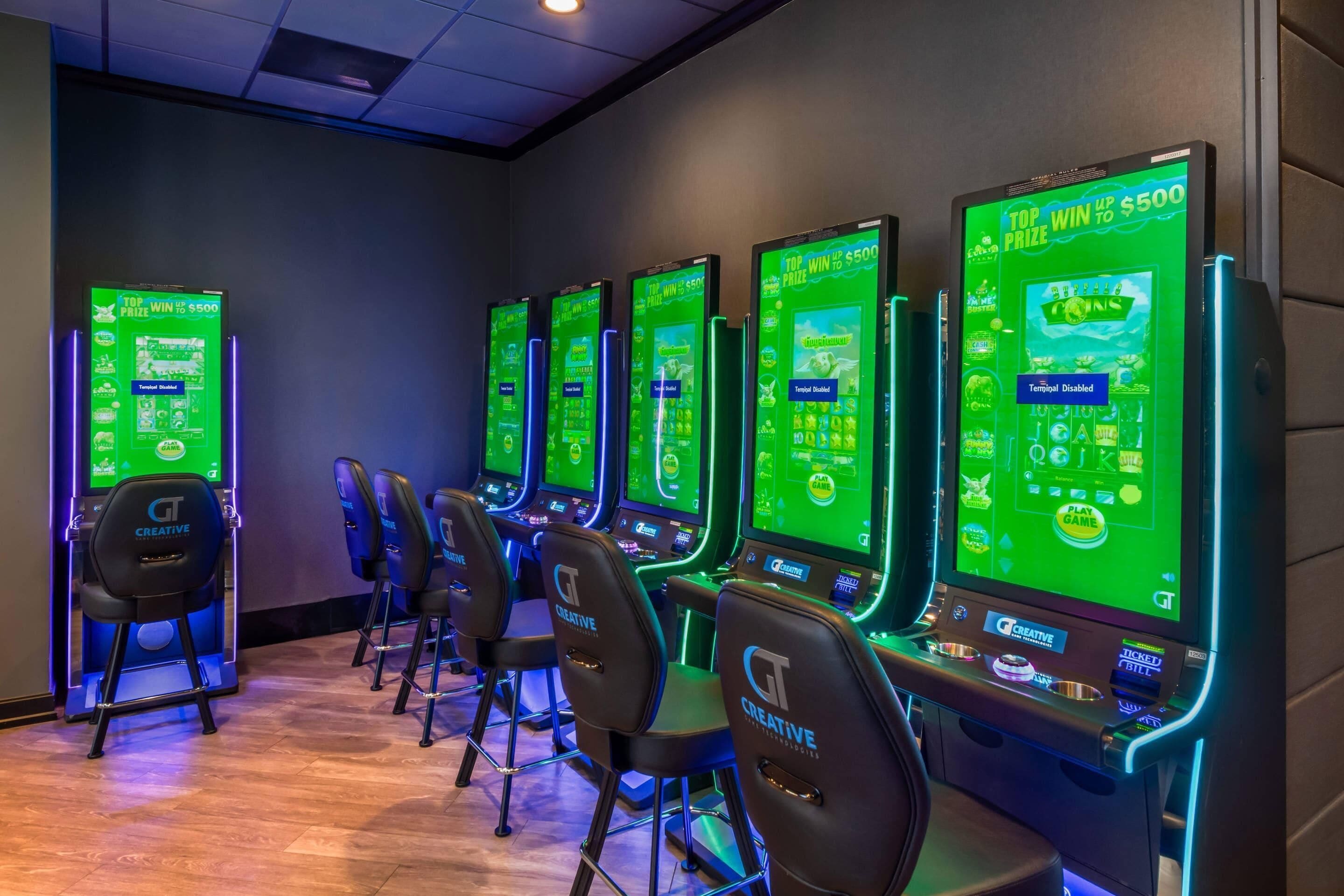 A row of gaming machines with a 'Top Win Up to $500' sign, chairs, and a 'Terminal Disabled' label.
