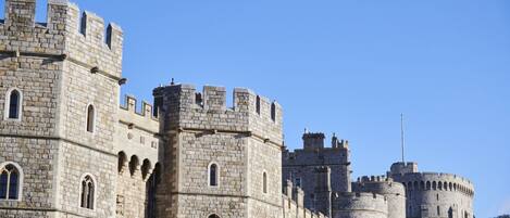 A historic stone castle with multiple towers and arched windows.