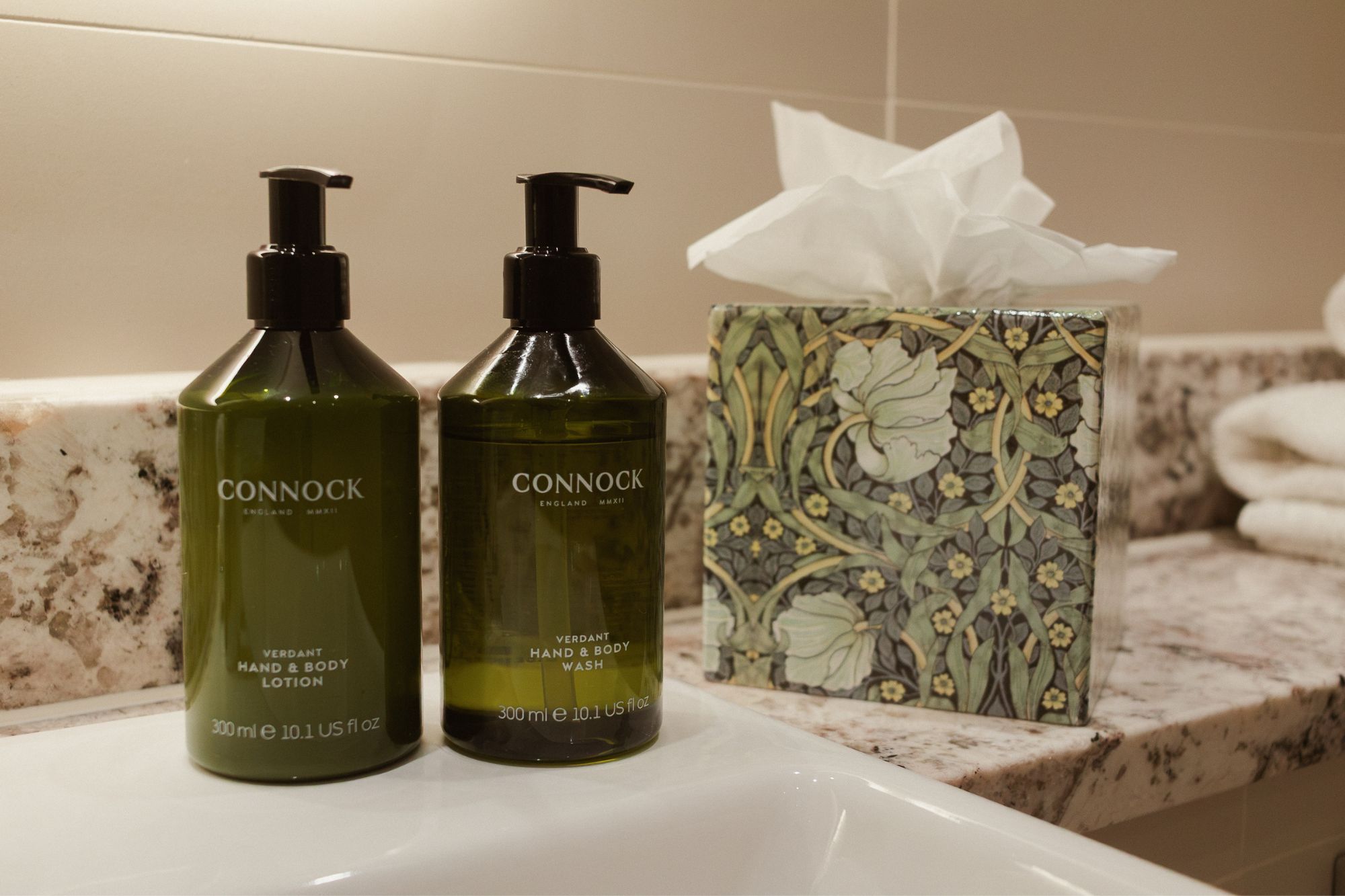 Two bottles of Connock hand and body wash on a bathroom counter.