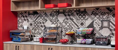 A breakfast bar with a self-serve pancake station, a fruit bowl, and a coffee station.