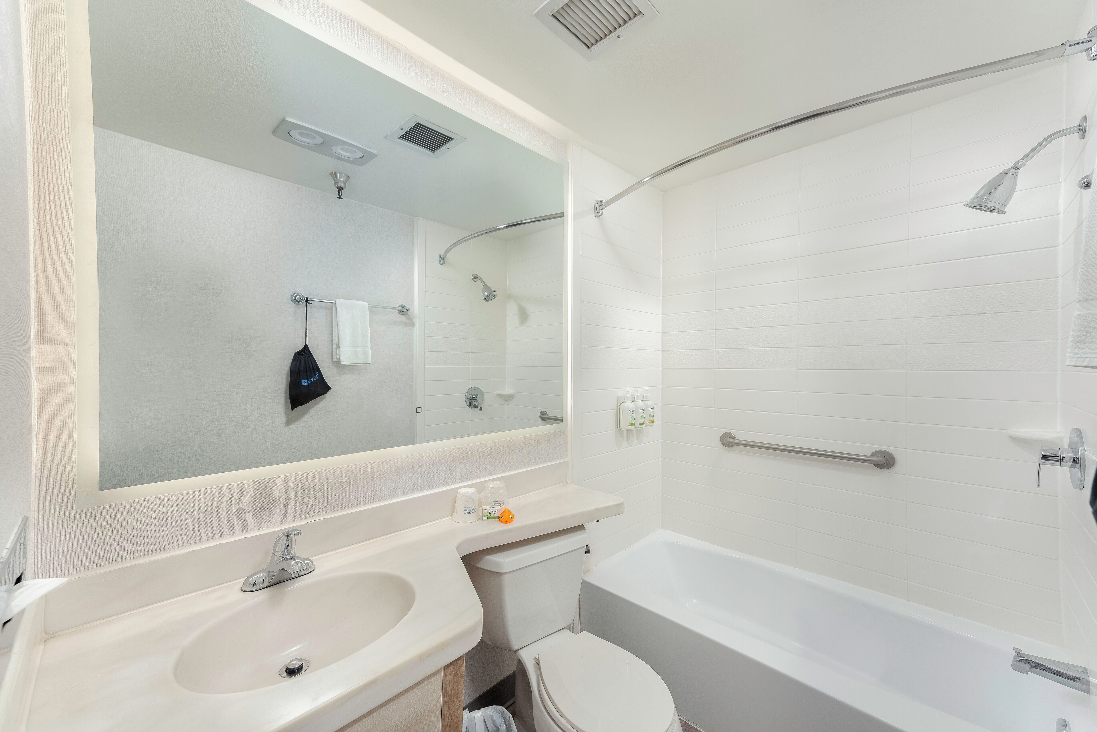 A modern bathroom with a sink, toilet, and bathtub.