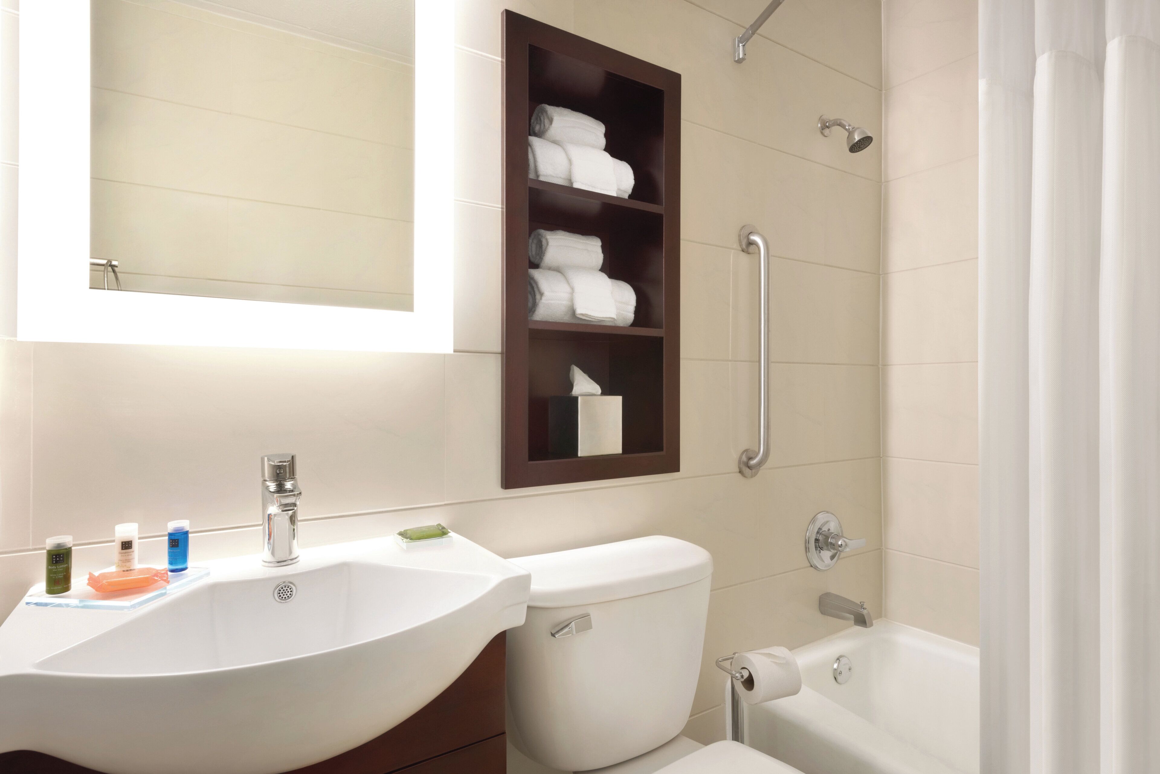 A bathroom with a white sink, a toilet, a bathtub, and a shelf with folded towels.