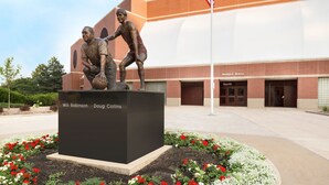 A statue of two figures in front of a building with a sign reading "Redbird Arena". - Holiday Inn Bloomington - Normal by IHG (Normal)