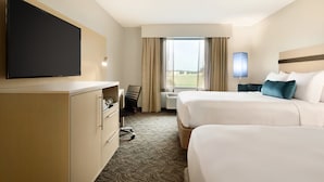 A hotel room with two beds, a flat-screen TV, a desk, and a large window with curtains. - Holiday Inn Bloomington - Normal by IHG (Normal)