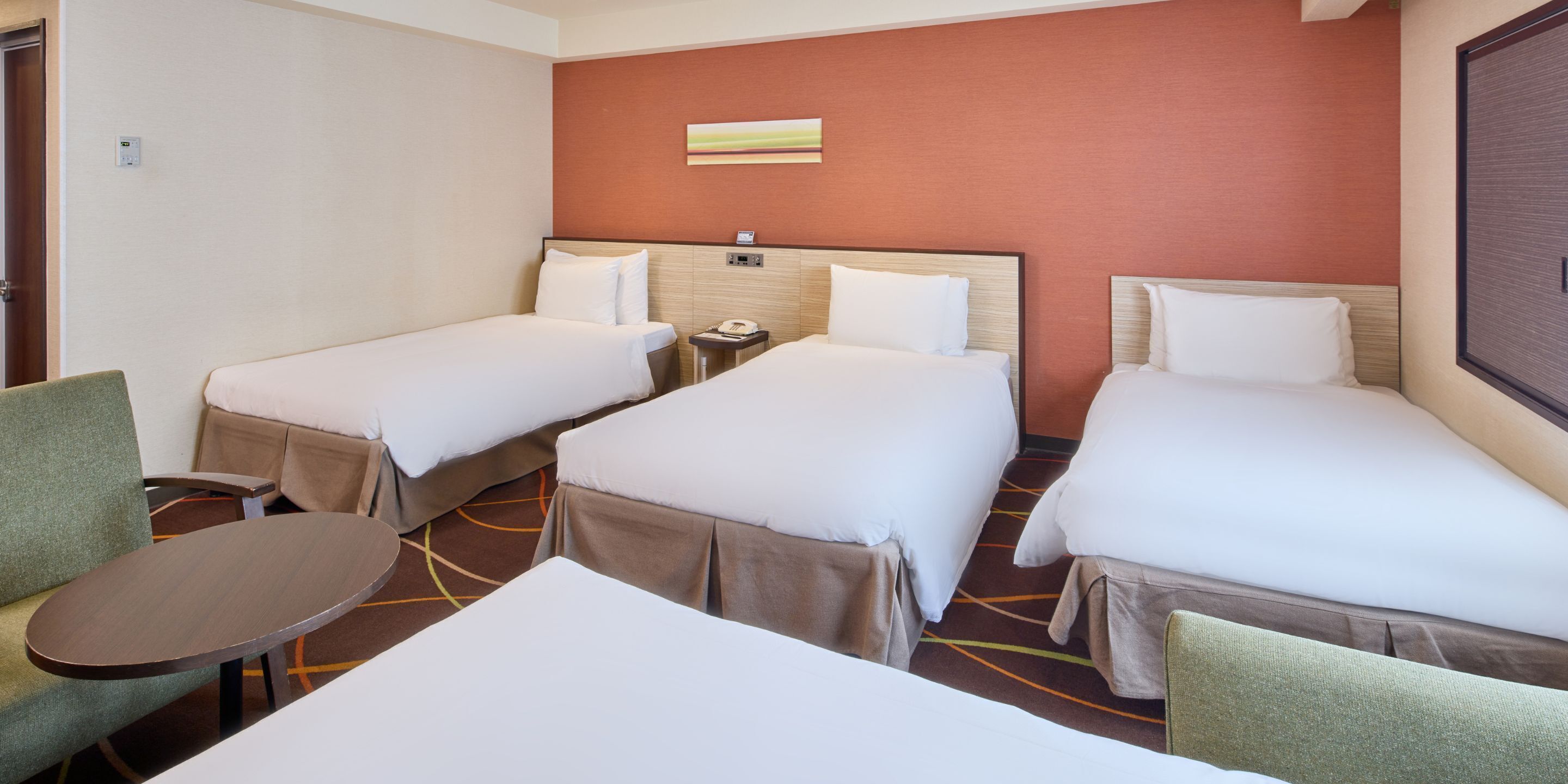 Una habitación de hotel con dos camas individuales, una mesita y una silla.