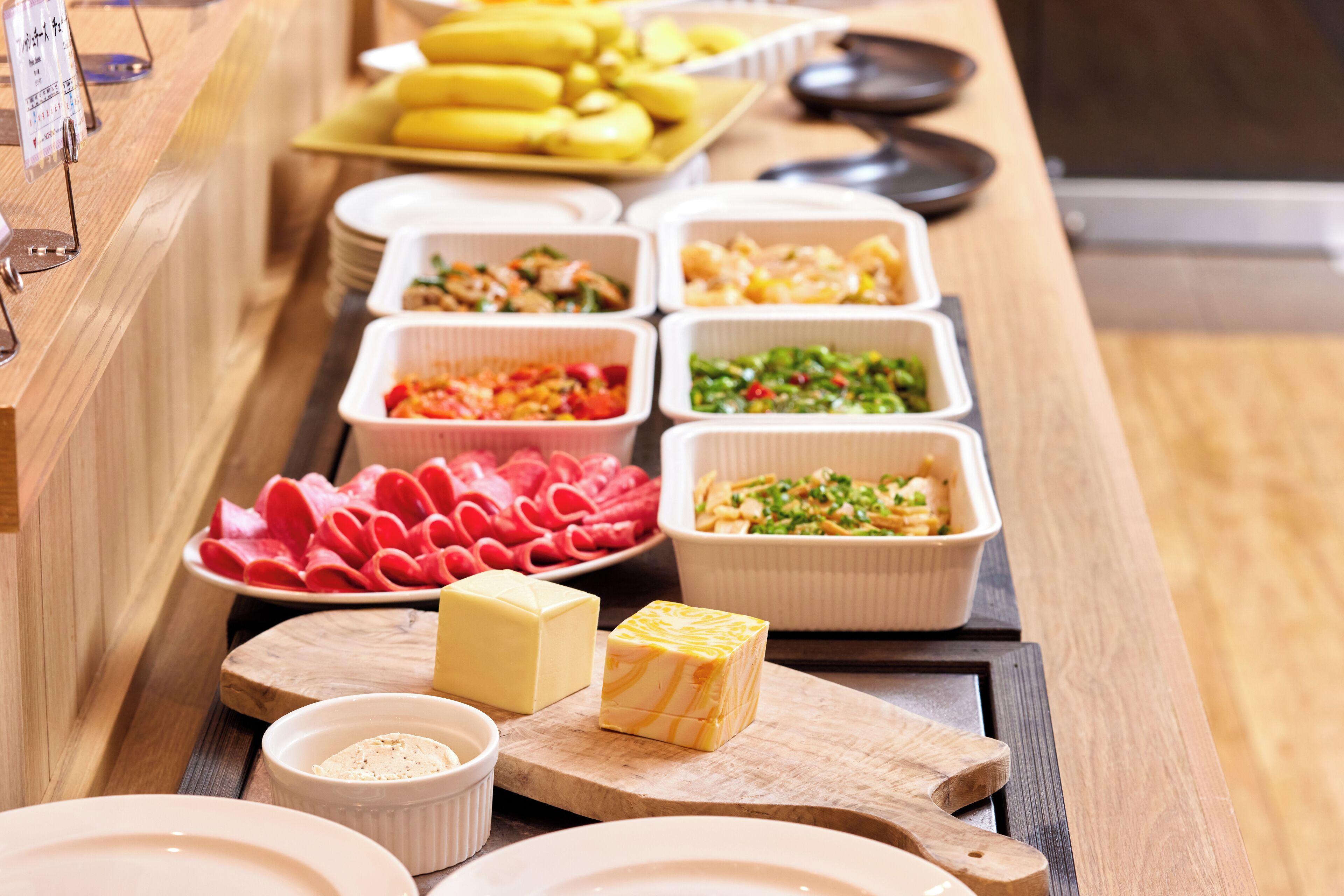 A buffet with various food items including meats, cheeses, and vegetables.