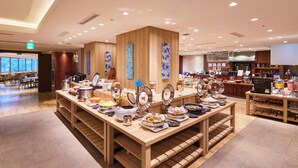 Een buffetruimte met diverse food stations en een zithoek met tafels en stoelen.