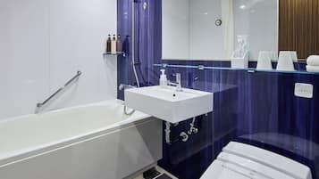 A modern bathroom with a white bathtub, a glass-enclosed sink, and a large mirror above the sink.