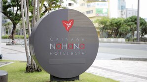 Een rond bord voor Okinawa Nahana Hotel & Spa, met een logo en de naam van het hotel.