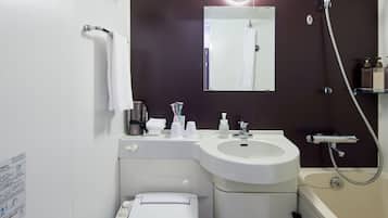 A bathroom with a white sink, a mirror, a towel rack, a shower, and a shelf with toiletries.