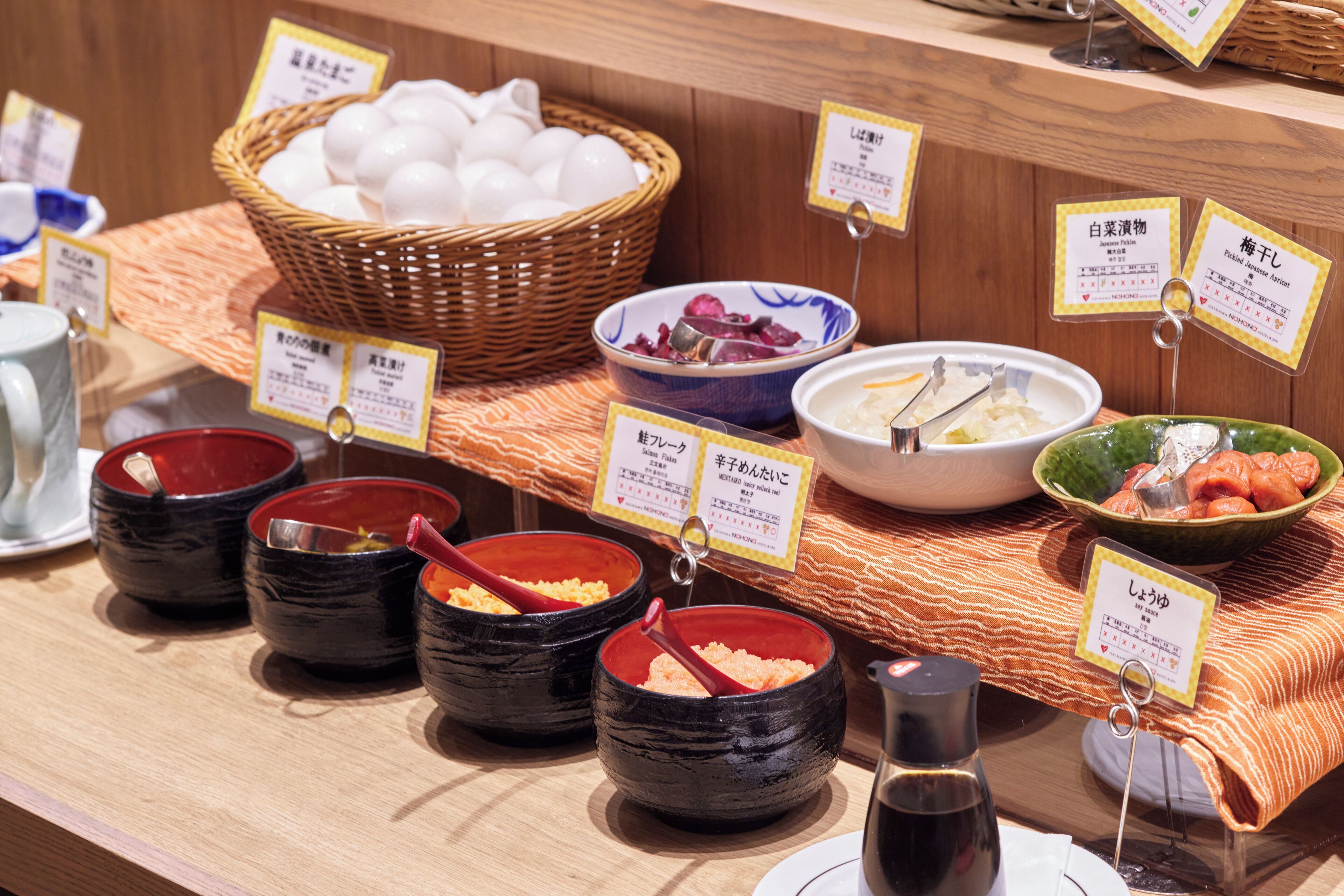 A buffet with various dishes and labels in a restaurant setting.