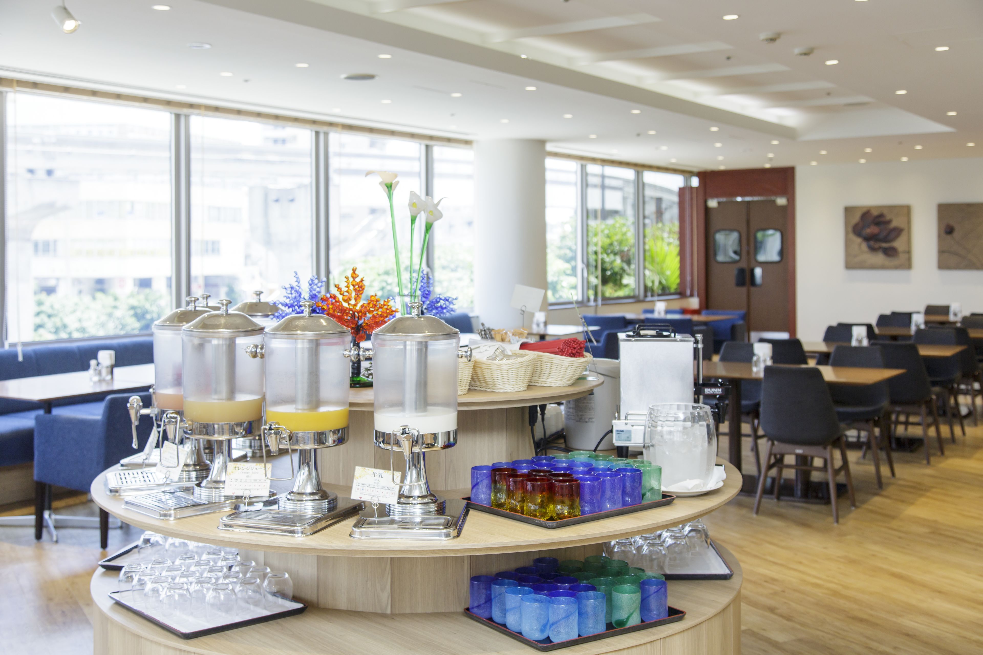 A buffet area with self-serve beverage dispensers, a variety of food items, and seating arrangements.