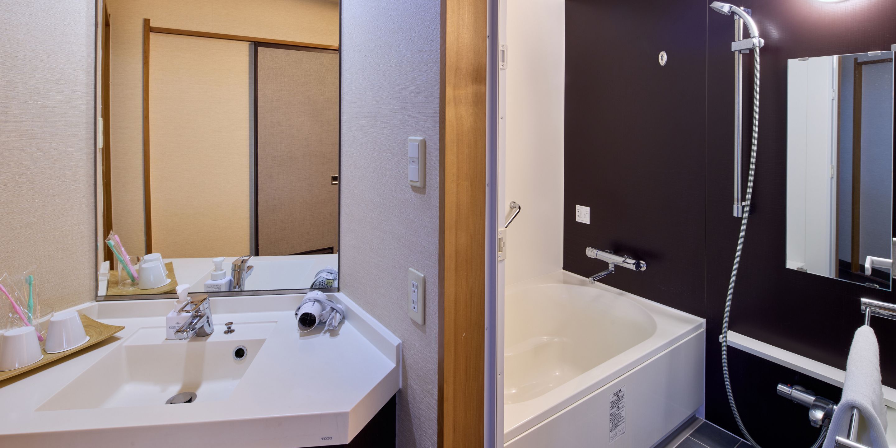 Ein Badezimmer mit Waschbecken, Spiegel und Badewanne.