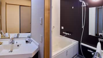 A bathroom with a white sink, mirror, and a bathtub with a shower head.