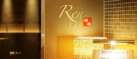 A bar named 'Ren BAR' with a sign in both English and Chinese, a menu board, and a patterned wall.