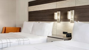 A hotel room with two beds, a wooden headboard, a bedside table with a lamp, and a control panel. - La Quinta Inn Lexington/Horse Park (Lexington)