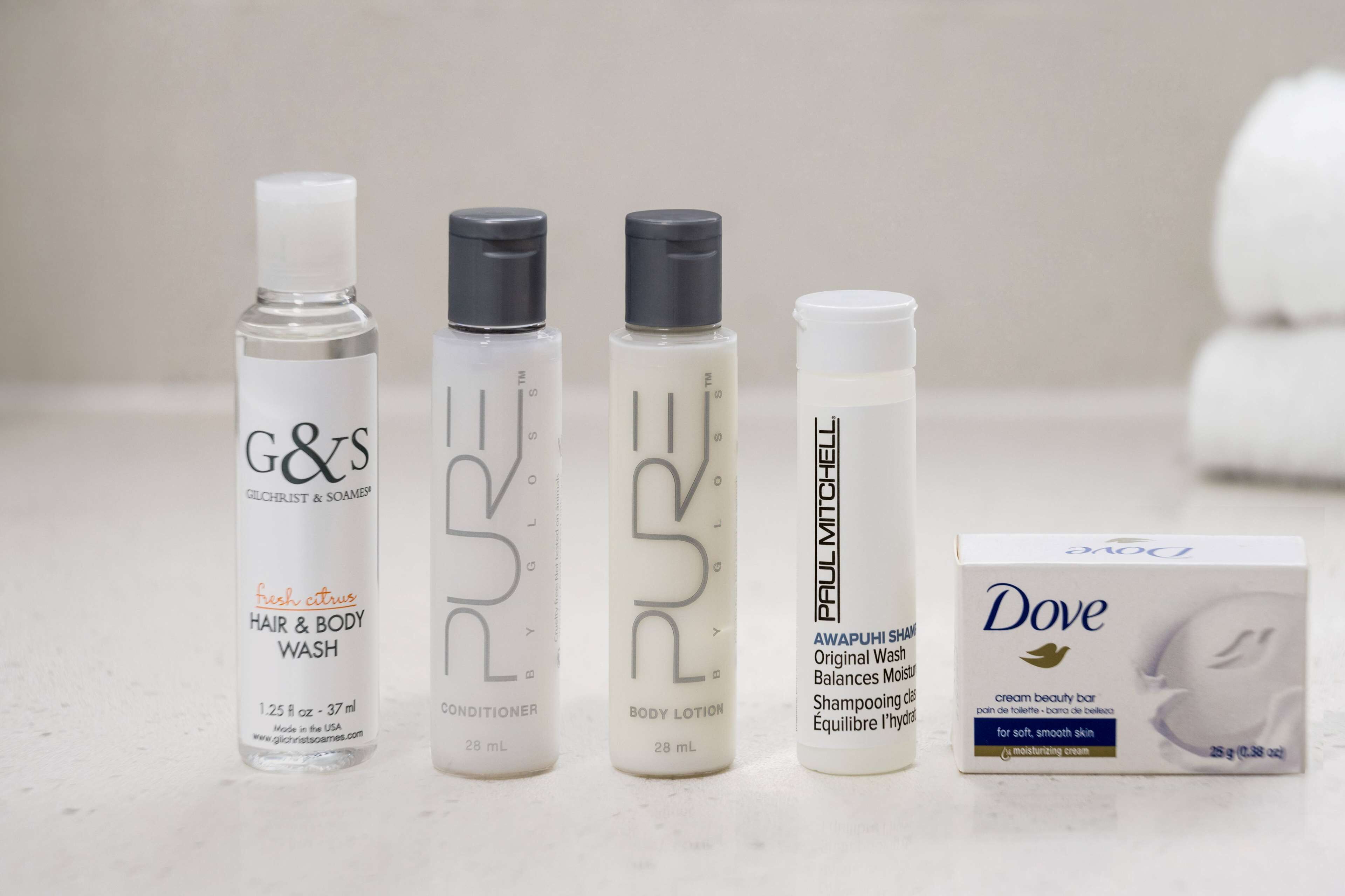 Cuatro botellas de gel de ducha y lavado capilar, y una barra de crema hidratante Dove.