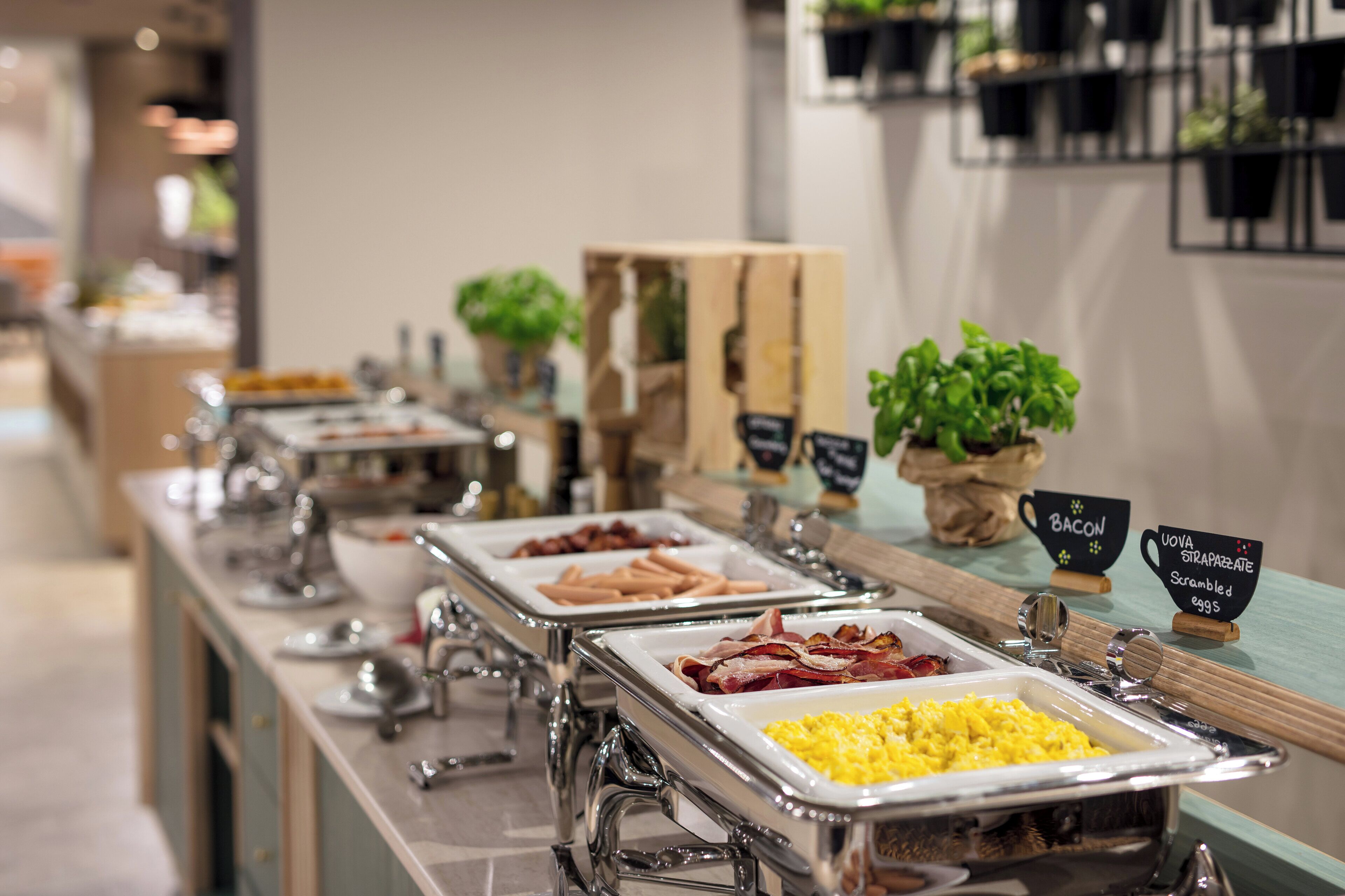 Ein reichhaltiges Frühstücksbuffet mit verschiedenen Speisen, darunter Speck, Rührei und weiteren Gerichten.