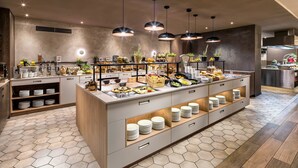 A modern breakfast bar with hexagonal tiles, stainless steel appliances, and a variety of food and drink options. - Holiday Inn Rome- Eur Parco Dei Medici by IHG (Rome)