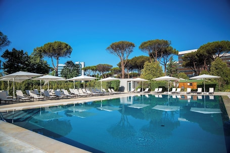 Seasonal outdoor pool, open 10:00 AM to 8:00 PM, pool umbrellas. Holiday Inn Rome- Eur Parco Dei Medici by IHG