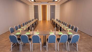 A conference room with a long table, chairs, and a podium.