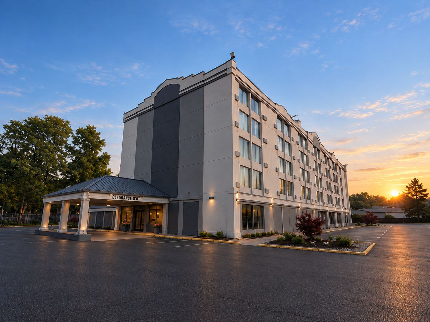 A multi-story hotel with a clear entrance and a parking lot.