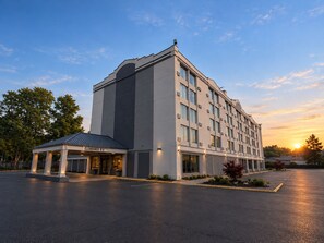 Un hotel de varios pisos con entrada despejada y estacionamiento.