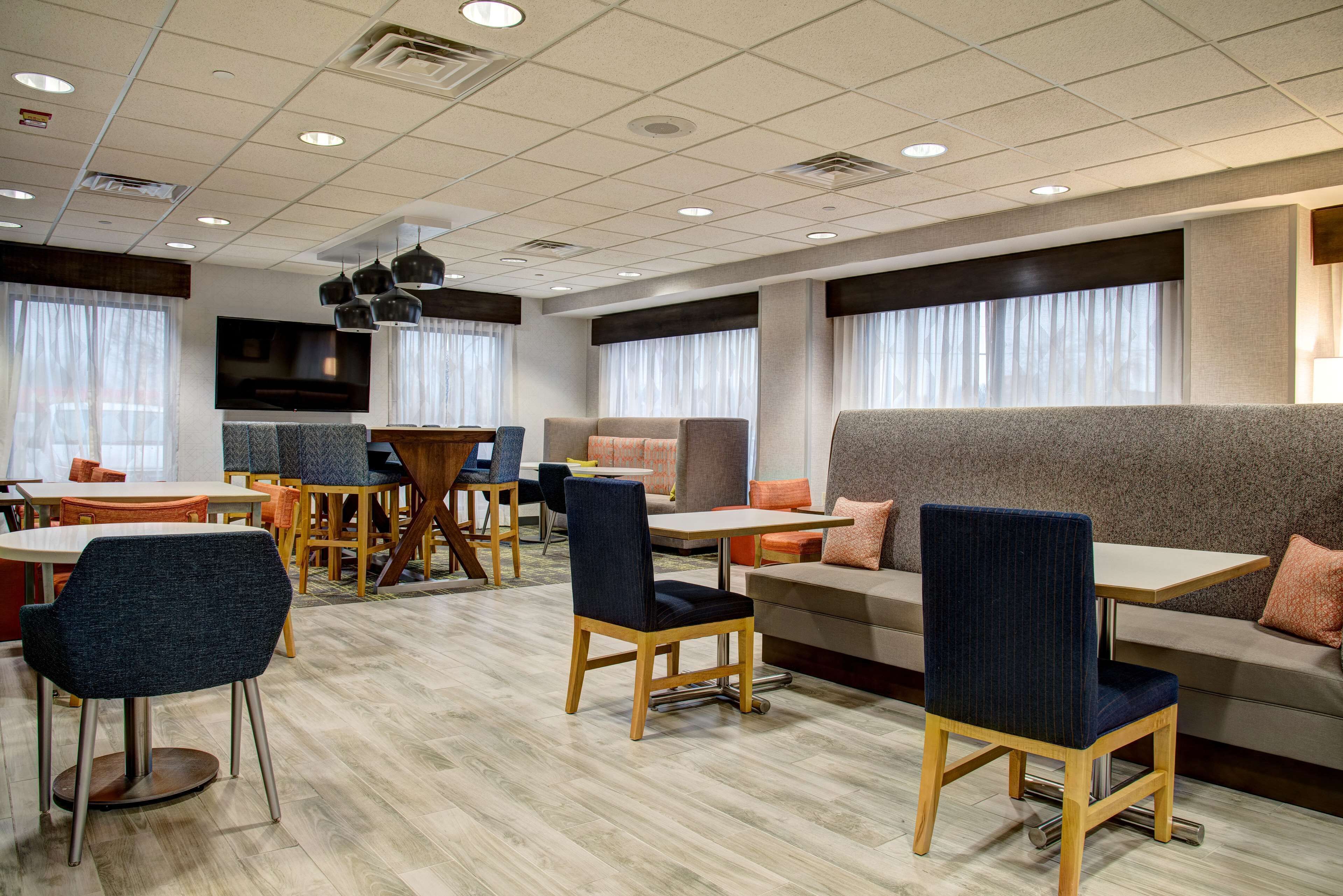 A modern hotel lobby with a mix of seating options including sofas, chairs, and tables.