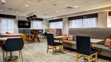 A modern hotel lobby with a mix of seating options including sofas, chairs, and tables.